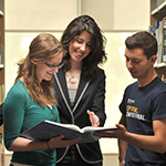 Thumbnail of librarian helping students in stacks